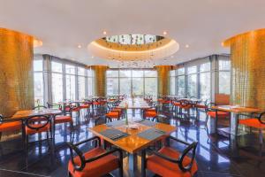 a restaurant with tables and chairs and a chandelier at Pullman Saigon Centre in Ho Chi Minh City