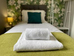 uma cama com duas toalhas em cima em The Capsule in Keswick em Keswick