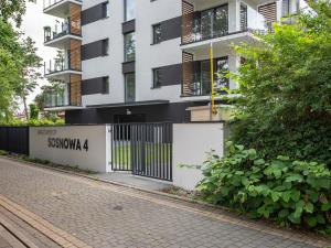 ein Gebäude mit einem Tor vor einer Straße in der Unterkunft VacationClub – Sosnowa 4 Apartament 44 in Mielno