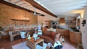 a living room with a couch and a kitchen at La Porcilaia in Castelnuovo Berardenga