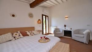 a bedroom with a bed with a table and two glasses of wine at La Porcilaia in Castelnuovo Berardenga +33 photos