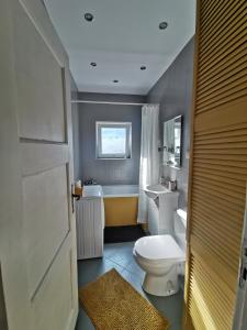a bathroom with a toilet and a sink and a tub at Comfortable apartment close to the center and sea in Gdańsk