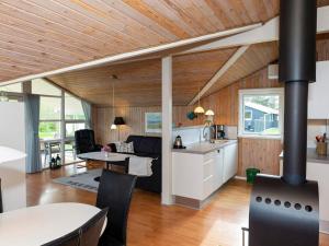 a kitchen and living room with a wood stove at 6 person holiday home in Hj rring in Lønstrup