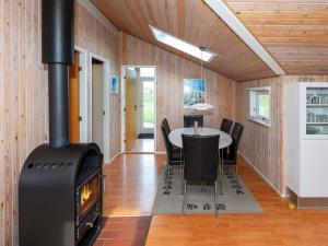 a wood stove in a dining room with a table at 6 person holiday home in Hj rring in Lønstrup