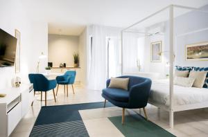 een slaapkamer met een bed en twee blauwe stoelen bij Glamorous flat with Jacuzzi and king size bed in Perugia