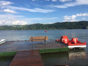 a dock with a bench and a boat on a lake at Znamirówka in Znamirowice