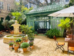 a conservatory with a fountain and potted plants in it at Garden Living - Boutique Hotel in Berlin