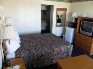a hotel room with a bed and a television at Knights Inn Palmdale in Palmdale