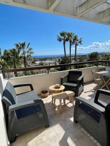 a balcony with chairs and tables and a view of the beach at Appartement vue exceptionnelle in Saint-Raphaël