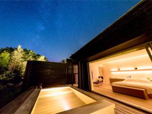 a bedroom with a bed on the deck of a house at 奥武雄温泉　風の森 in Ureshino