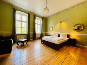 Garden Living - Boutique Hotel في برلين: غرفة نوم خضراء بسرير وطاولة