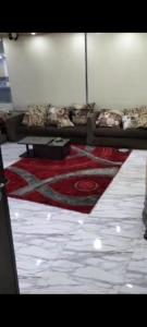 Habitación con cama con alfombra roja en شقه سكنيه, en El Cairo