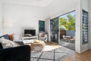 a living room with a couch and a tv at Marie's Byron Getaway in Byron Bay