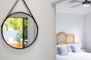 1 dormitorio con espejo en la pared en Marie's Byron Getaway, en Byron Bay