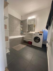 a bathroom with a washing machine and a sink at Chambre dans logement neuf, Paris, Disney, Centrex in Noisy-le-Grand