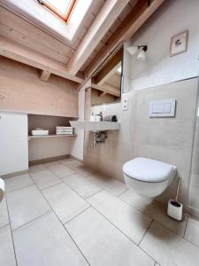 a bathroom with a toilet and a sink at Gästehaus Bergwinkl in Reit im Winkl +32 photos