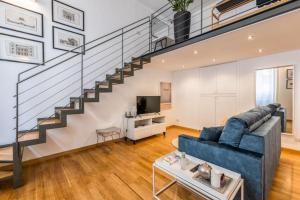 a living room with a blue couch and stairs at Loft Crocetta in Turin