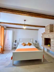 a bedroom with a bed and a brick fireplace at Val Comeza in Komiža