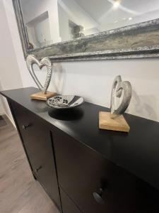 a black dresser with two heart shaped sculptures on it at Sweet Home in Valencia