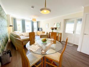 een woonkamer met een glazen tafel en stoelen bij Ockendon House Apartments in Torquay