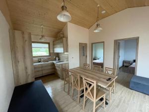 a kitchen and dining room with a wooden table and chairs at DOMKI NAD ŁOWISKIEM in Giżycko