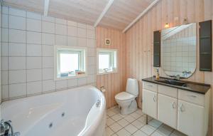 a bathroom with a tub and a toilet and a sink at Beautiful Home In Nakskov With Sauna in Nakskov