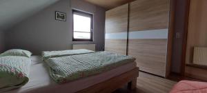ein kleines Schlafzimmer mit einem Bett und einem Fenster in der Unterkunft FeWo Schmidt im Erzgebirge in Gelenau