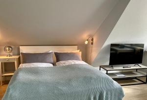a bedroom with a bed and a flat screen tv at Haus Eberhardt Appartement 2 in Tinnum