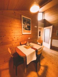 uma sala de jantar com uma mesa numa sala de madeira em Naturnahes Familienchalet mit Garten - Wifi - Netflix - nur 15 Minuten vom Chiemsee und 35 Minuten von München entfernt em Vogtareuth