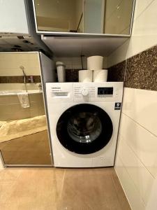 een wasmachine en droger in een kleine keuken bij Centrum Apartments Pstrossova in Praag