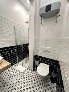 プラハにあるセントラム アパートメンツ プシュトロスソヴァの黒と白のタイルを用いたバスルーム(トイレ付)