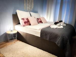 uma cama com almofadas cor-de-rosa e animais de peluche em Elbling Apartment mit Terrasse - Netflix - Parkplatz - Weinbergblick em Meißen