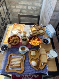 una mesa cubierta con diferentes tipos de pan y comida en Porta7 Hotel, en Gjirokastra