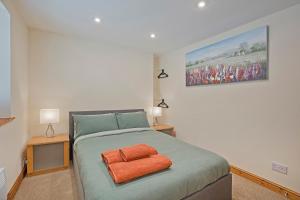 Un dormitorio con una cama con una toalla naranja. en Tom's cabin en Knaresborough