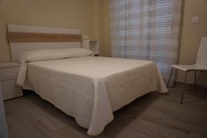プエルト・デ・サグントにあるMediterrania Marinaのベッドルーム(白いベッド1台、椅子付)