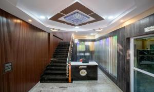 - un hall avec des escaliers et un plafond orné d'un lustre dans l'établissement Treebo Trend 3C Comforts, à Chikmagalur