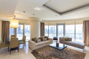 SuperHost EMAAR Residences Fashion Avenue - Address Dubai Mall في دبي: غرفة معيشة مع أريكة وطاولة