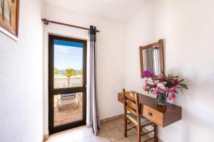 a door leading to a balcony with a table and flowers at Beach Front A in Luz