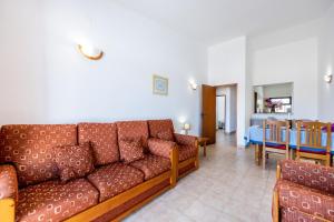 a living room with a couch and a dining room at Beach Front A in Luz