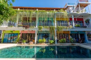 a hotel with a swimming pool in front of a building at Dragon Dive Komodo Dive Resort in Labuan Bajo