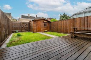 a wooden deck with a bench and a fence at Charming 3BR house with garden in Cambridge - Cherry Hinton in Cherry Hinton