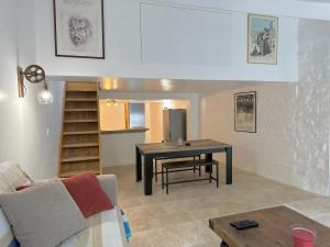 a living room with a table and a couch at Chez Romain et Saphie in Les Baux-de-Provence