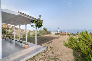 Una hilera de plantas en macetas bajo un pabellón. en Stegna Silence Seaview, en Archangelos
