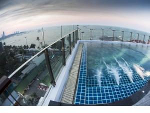 a swimming pool on top of a building with the ocean at Serenotel Pattaya in Pattaya