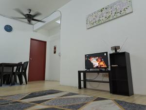 a living room with a flat screen tv and a table at 1201 Apartment Ladang Tok Pelam TepiPantaiBatuBuruk in Kuala Terengganu