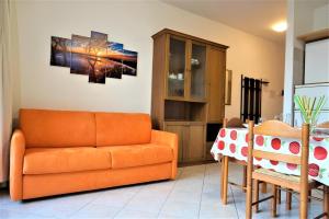 a living room with an orange couch and a table at 1Dest - Waterfall & Pool with Garden in Riva del Garda