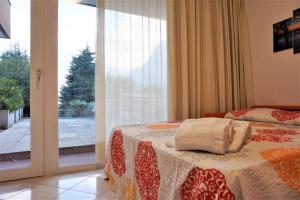 a bedroom with a bed and a large window at 1Dest - Waterfall & Pool with Garden in Riva del Garda