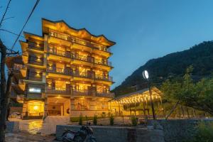 un edificio di un hotel con una moto parcheggiata di fronte di The Social Stays Manali formerly ArtBuzz a Manāli