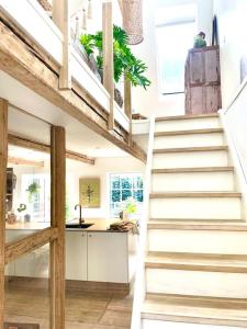 a staircase in a house with a kitchen in the background at Vidunderligt hus m/egen gårdhave - midt i centrum in Aalborg