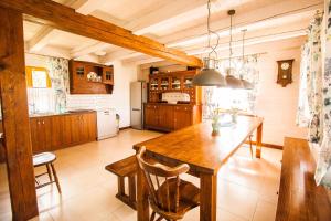 a kitchen with a wooden table and a dining room at Holiday House Folwark Jeleń in Poniklica